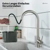 A hand is pulling a kitchen faucet spray head over a pot in a sink. Produktbild-Vorschau