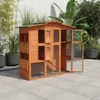 A wooden chicken coop with multiple compartments and doors, set up on a paved patio with plants in the background.