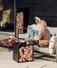 Two women are sitting on a sofa on a patio next to a fire pit and a wood storage unit. Podgląd zdjęcia produktu