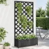 A planter box with a trellis attached, filled with plants, is placed against a white wall outdoors. A table and chair are visible in the background. Anteprima dell’immagine prodotto