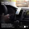 A person's hand is on the steering wheel of a car, with a smartphone mounted on the air vent. A small black device is attached to the air vent near the phone. Anteprima dell’immagine prodotto