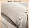 Close-up of beige chenille fabric with icons and text indicating features. Produktbild-Vorschau