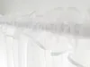 A close-up view of white sheer curtains hanging from a rod. Produktbild-Vorschau