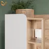 A close-up view of a white cabinet with a wooden shelf unit next to it, decorated with a plant in a woven basket. Produktbild-Vorschau