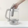 A hand is shown placing a cloth into a glass electric kettle. Produktbild-Vorschau