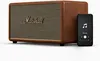 A brown Marshall wireless Bluetooth speaker is shown next to a smartphone displaying a music player interface. Produktbild-Vorschau