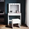 A white vanity table with a lighted mirror and a matching stool against a dark blue wall. Voir les images du produit