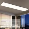 A rectangular LED panel light is mounted on a ceiling in a room with curtains and furniture visible. Produktbild-Vorschau