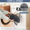A person is putting a gray dog bed into a washing machine. Voir les images du produit