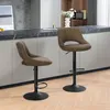 Two brown bar stools are placed in a modern kitchen setting, next to a counter. Produktbild-Vorschau