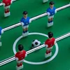 A close-up view of a foosball table with several player figurines and a soccer ball. Náhľad obrázku produktu