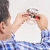 A person is changing the battery in a smoke detector. Produktbild-Vorschau