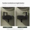 Two identical black wall-mounted sinks are shown side-by-side, each with a black faucet with a gold accent. The image highlights different installation options. Anteprima dell’immagine prodotto