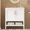 A white bathroom vanity with a gold faucet and a round mirror above it. Voir les images du produit