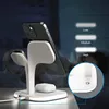 A charging station for electronic devices is shown in a dimly lit room with a person sleeping in the background. Produktbild-Vorschau