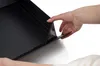A hand is shown folding the corner of a black gift box. Podgląd zdjęcia produktu