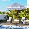 An outdoor patio scene with a striped umbrella, chairs, and a swimming pool. Produktbild-Vorschau