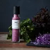 A bottle of pink salt with herbs and shredded red cabbage on a wooden table. Produktbild-Vorschau