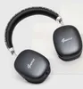 A pair of black GUESS wireless headphones with a metallic script logo on a light gray and white background. Produktbild-Vorschau