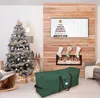 A Christmas tree storage bag is shown in a living room setting with a decorated Christmas tree and fireplace in the background. Voir les images du produit