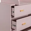Close-up view of the drawers of a pink dresser with wooden handles. Podgląd zdjęcia produktu