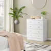 A bedroom scene featuring a white dresser and a bed. Náhľad obrázku produktu