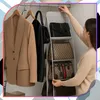 A woman is organizing handbags in a closet using a hanging organizer. Produktbild-Vorschau