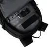 Close-up view of the interior of a black backpack, showing a phone and a charging cable in a zippered pocket. Produktbild-Vorschau