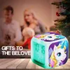 A family is in the background, with a Christmas tree on the right and a unicorn alarm clock in the foreground. Produktbild-Vorschau