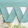 A close-up view of a teal fabric curtain with pleats, set against a background of daisies. Produktbild-Vorschau