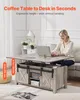 A woman is using a lift-top coffee table as a desk in a living room. Produktbild-Vorschau
