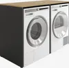 A white washing machine and dryer are shown next to each other, with a dark gray cabinet and a wooden countertop. Produktbild-Vorschau