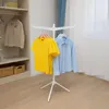 A white, foldable drying rack with clothes hanging on it, placed in a room with a closet and a window. Produktbild-Vorschau