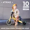 A baby sits on a yellow and black tricycle in a studio setting. Produktbild-Vorschau