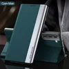 A teal and silver phone case is displayed in a studio setting, with one case open and standing, and another closed. Produktbild-Vorschau