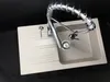 A kitchen sink with a faucet against a black background. Náhled obrázku produktu