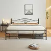 A black metal bed frame with a mattress and bedding, set up in a bedroom with a nightstand and a picture on the wall. Produktbild-Vorschau