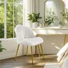 A white upholstered chair with gold legs sits in front of a dressing table with a mirror. Produktbild-Vorschau