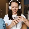 A young woman wearing headphones and looking at her phone. Náhled obrázku produktu