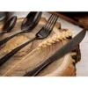 Close-up of black cutlery and a wheat stalk on a wooden surface. Náhled obrázku produktu
