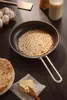 A pancake is being cooked in a frying pan, with ingredients like eggs and milk nearby. Podgląd zdjęcia produktu