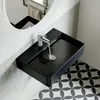 A black rectangular sink with water running into it, mounted on a tiled wall. Produktbild-Vorschau