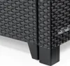 A close-up view of the legs and woven texture of a dark-colored outdoor chair. Produktbild-Vorschau