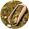 A close-up of yerba mate tea leaves and dried fruit in a wooden scoop. Anteprima dell’immagine prodotto