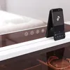 A close-up view of a modern vanity mirror with integrated controls and a smartphone displaying a music app. Náhled obrázku produktu
