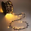 A spool of fairy lights with the lights unspooled and laid out on a surface. Produktbild-Vorschau