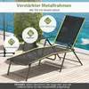 A black and yellow sun lounger is shown on a wooden deck with a blurred background of water and greenery. Náhled obrázku produktu