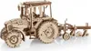 A wooden model of a tractor with a plow attachment, shown from a side-angle against a white background. Náhľad obrázku produktu