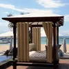 A cabana with curtains on a beach next to a pool. Náhled obrázku produktu