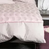 A close-up view of a duvet cover with a circular pattern. Produktbild-Vorschau